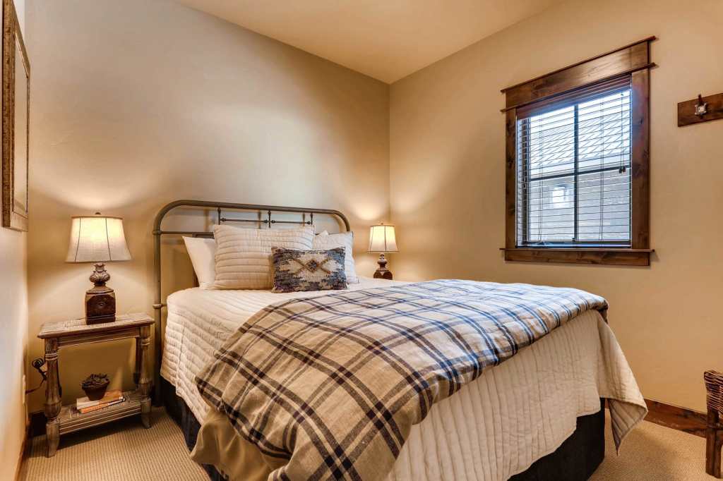 Cozy Canoe queen bedroom with iron bed, nightstands and window